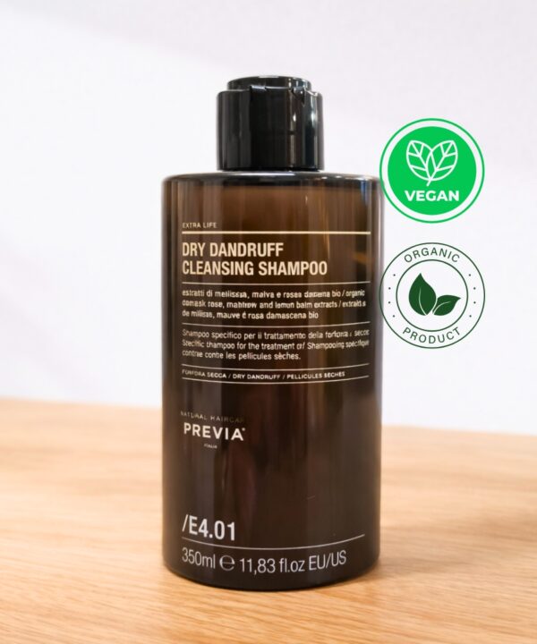 Frasco de Previa Scalp Ritual Dry Dandruff em tom âmbar sobre uma superfície de madeira. Este shampoo caspa seca da linha Extra Life contém extratos de melissa e rosa damascena bio. É um shampoo couro cabeludo de 350ml com a referência /E4.01, desenvolvido para tratar a descamação seca. No canto superior direito, surgem os selos "Vegan" e "Organic Product", reforçando a composição natural e sustentável da Previa Italia.